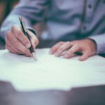 a person writing on a piece of paper